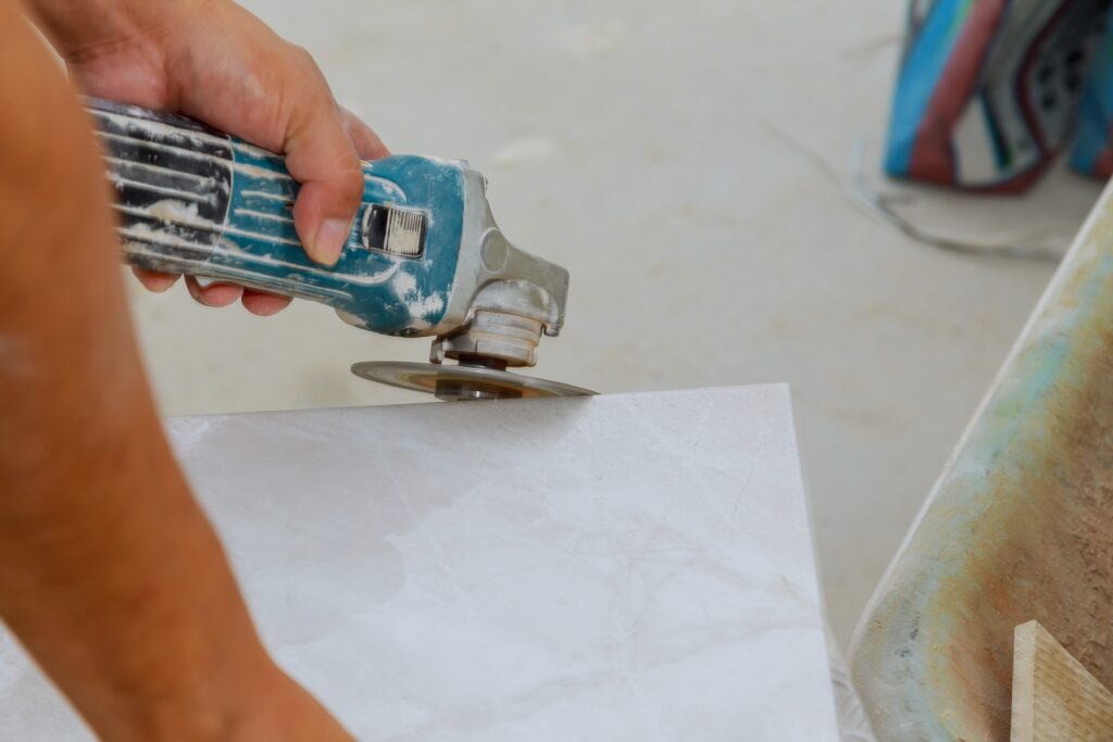 Worker uses grinder for cutting tiles porcelain stoneware work trimming tiles